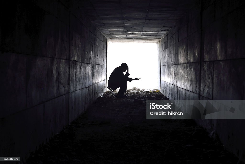 sad man sitting in the tunnel man waiting to help poor single-handed. Begging - Social Issue Stock Photo