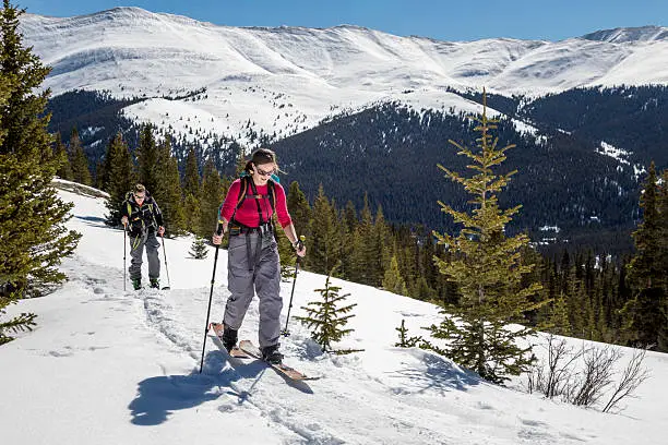 Two people touring on splitboards and alpine touring skis