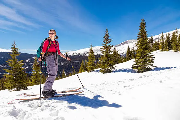 A woman touring in the backcountry on a splitboard.
