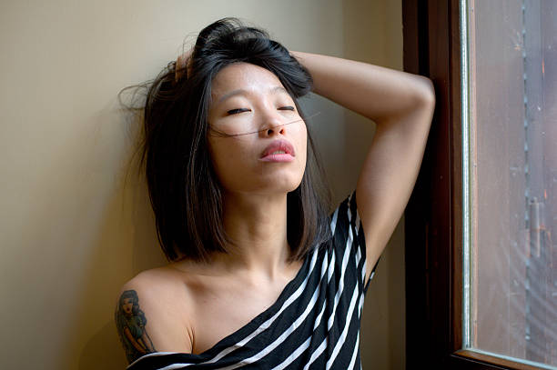 istock Beautiful sensual asian woman posing thoughtful at window 468585476