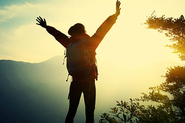 istock cheering woman hiker open arms at mountain peak 468585494