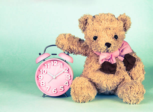 istock Old fashioned alarm clock and cute brown bear doll 468590570