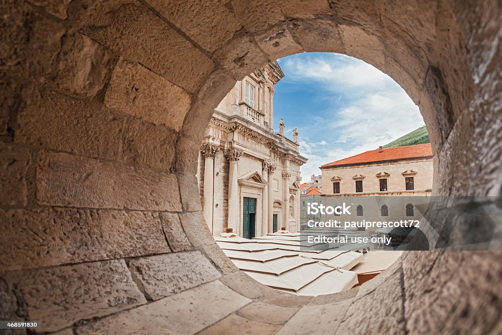 View on The Assumption Cathedral entrance Dubrovnik, Croatia - May 26, 2014: View on The Assumption Cathedral entrance through circular stone opening. Cathedral is the seat of the Roman Catholic Diocese of Dubrovnik. Macrophotography Stock Photo