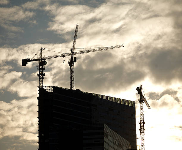 istock Contours of tower cranes above office building 468592664