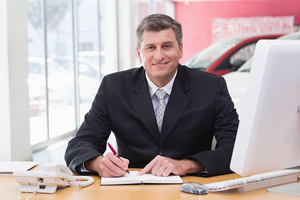 istock Smiling businessman writing on clipboard at his desk 468593404