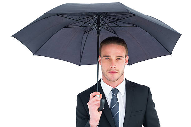 istock Unsmiling businessman sheltering under umbrella 468598952