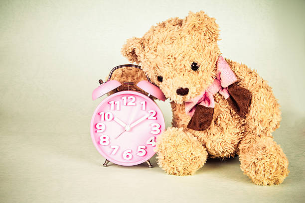 istock Old fashioned alarm clock and cute brown bear doll 468598994