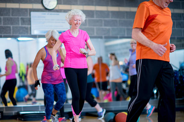 Group Exercise A group of seniors and young adults, working out in a dance / exercise class at a health club. circuit training stock pictures, royalty-free photos & images