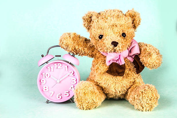 istock Old fashioned alarm clock and cute brown bear doll 468601502
