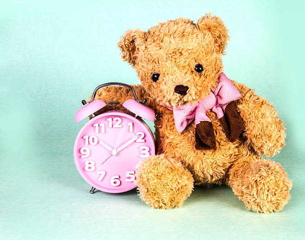 istock Old fashioned alarm clock and cute brown bear doll 468601510