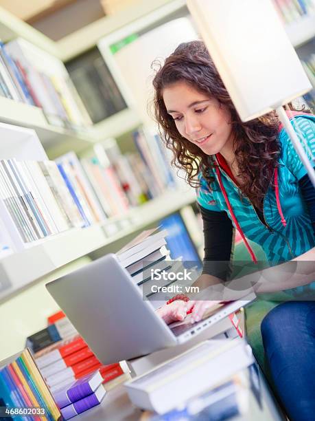 Mujer Joven Con Ordenador Portátil En La Biblioteca Foto de stock y más banco de imágenes de 20-24 años