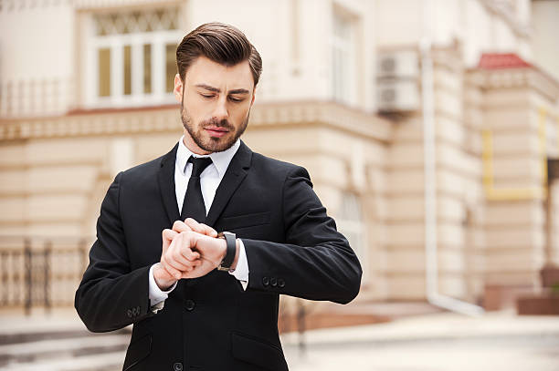 istock A man in a suit checking his watch 468602820