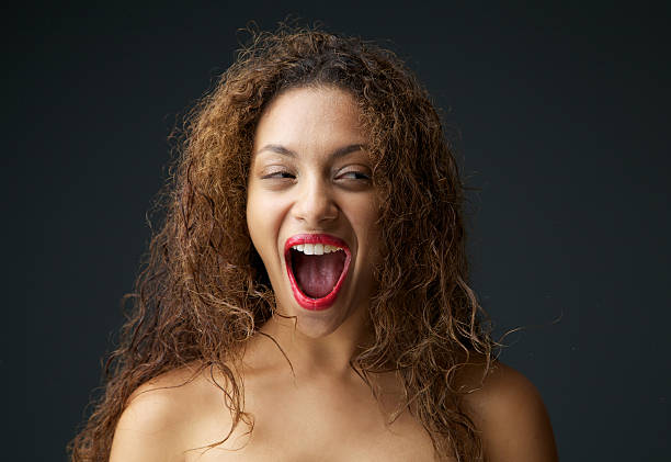 mujer joven excitación y riendo con boca abierta - studio shot mouth open horizontal head and shoulders fotografías e imágenes de stock