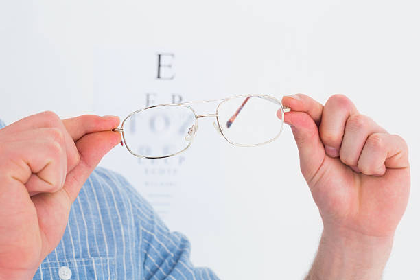 istock Hands holding glasses for eye test 468606182