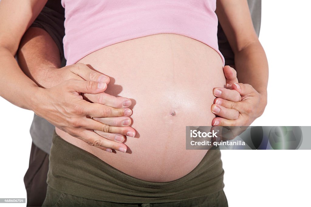 couple in love tummy pregnancy man and woman holding hands on front of naked paunch eight month pregnant isolated over white background 2015 Stock Photo