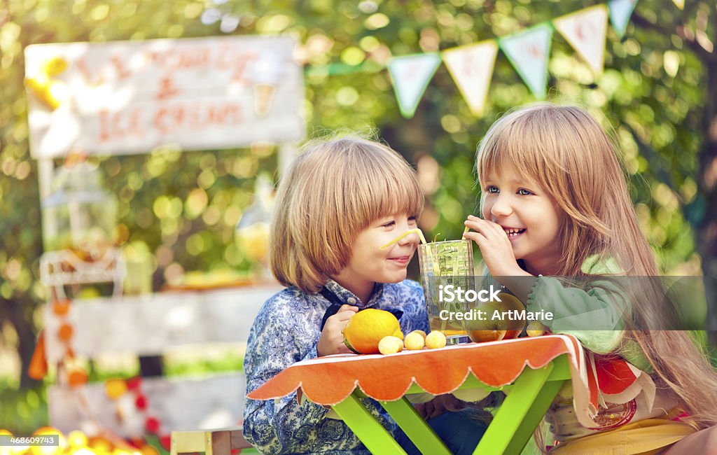 Young love Little boy and girl in the park drinking lemonade at their first dating Affectionate Stock Photo