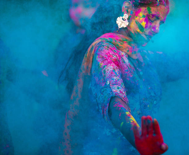 Blue colors during Holi in India Young woman dancing around blue powder while celebrating the Indian Holi Day holi stock pictures, royalty-free photos & images