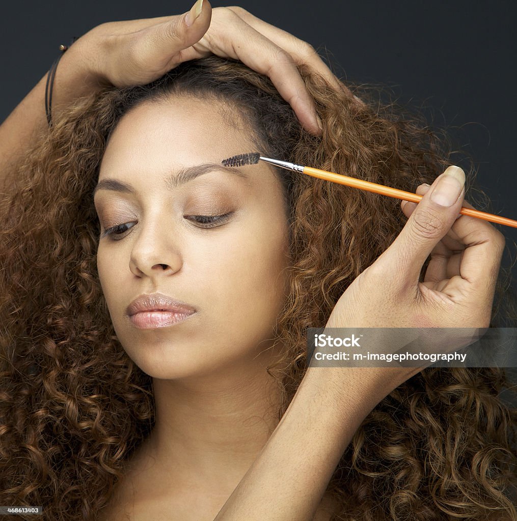 Beautiful woman having eye make up application from professional Close up portrait of a beautiful woman having eye make up application from professional Eyebrow Stock Photo