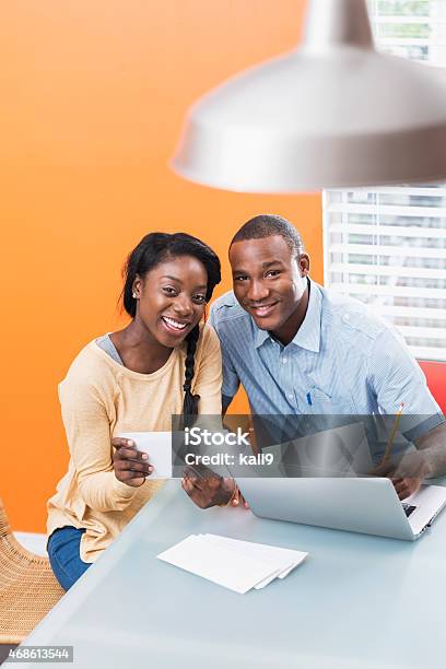 Young Black Couple Paying Bills At Home Stock Photo - Download Image Now - 20-29 Years, 2015, Adult