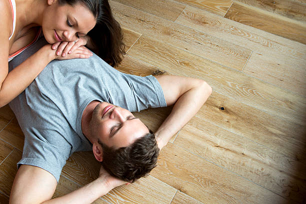 istock Couple lying on hard Wood Floor 468614569