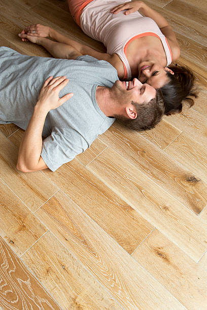 istock Couple lying on hard Wood Floor 468614721