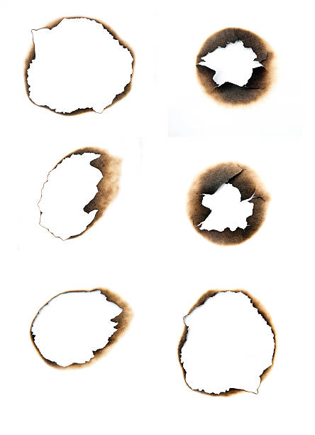 istock Burned holes in a piece of white paper. 468617561