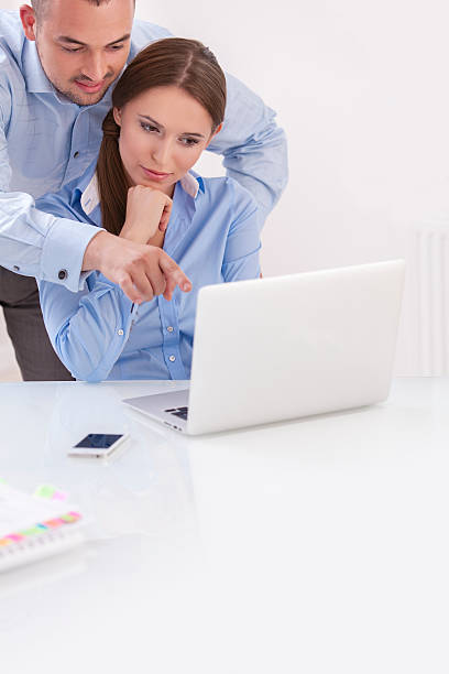 istock Businessman and businesswoman working together on a computer 468618717