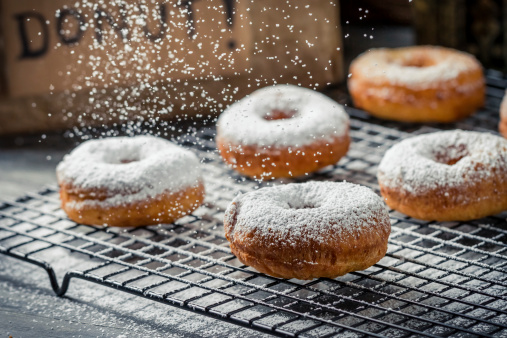Donuts decorated with powder sugar.