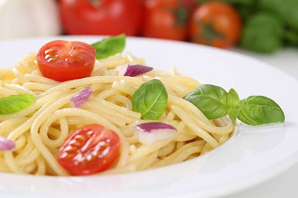 istock Spaghetti noodles pasta meal with tomatoes and basil on plate 468628100