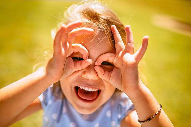 istock Little girl posing with hands making spectacles around her eyes 468628986