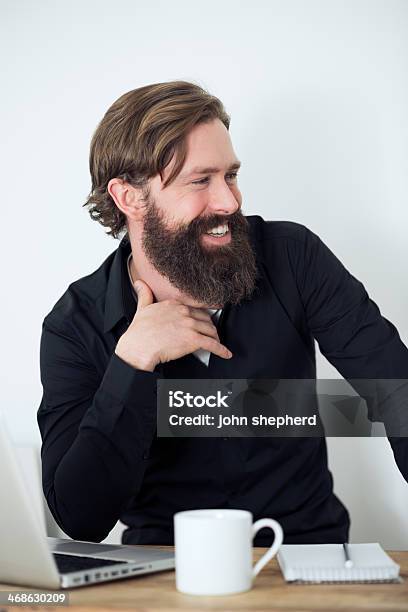 Bearded Laughing Man Working At Desk Stock Photo - Download Image Now - 30-39 Years, Adult, Adults Only