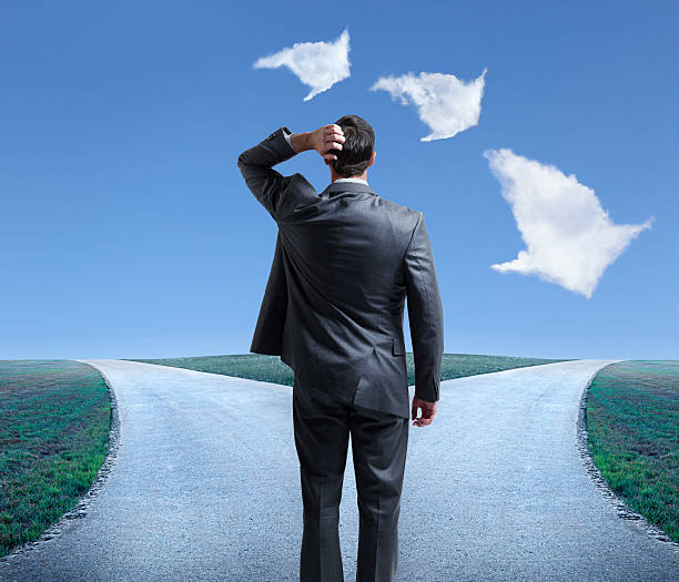 istock Clouds helping businessman with choices at forked road 468631294