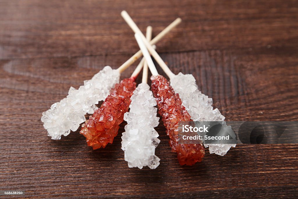 Crystal brown and white sugar candy on brown wooden background 2015 Stock Photo