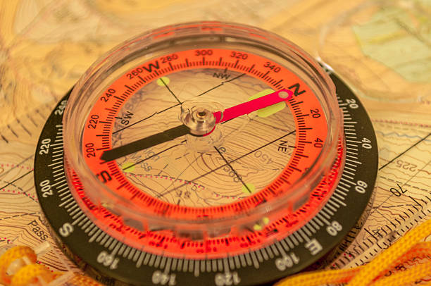 kompass auf einer karte - orienteering planning mountain climbing compass stock-fotos und bilder