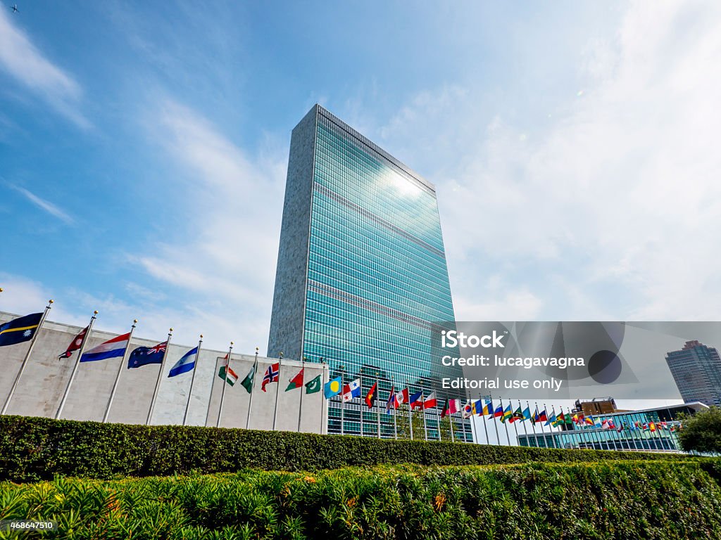 A headquarter New York City, USA - August 21, 2014: UN Headquarters in a summer day. Many flags are blowing this means that the assembly is meeting United Nations Building Stock Photo