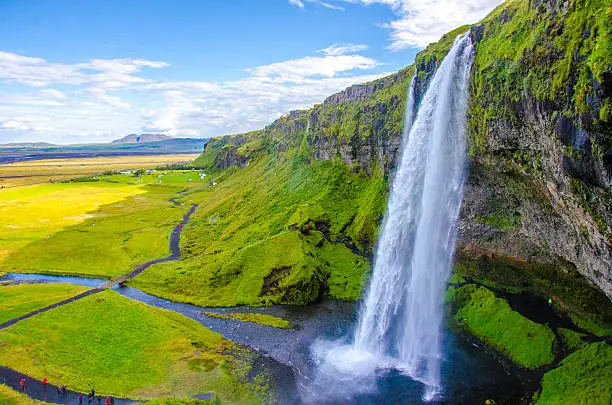 Panoramic view of the idyllic Seljalandsfoss waterfall on a sunny day in summer.