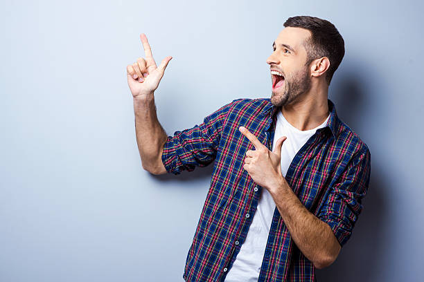 istock Happy man in plaid shirt pointing upward 468649068