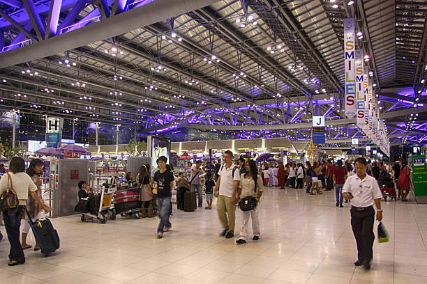 Bangkok, Thailand - May 22, 2011: Passengers walking through the Airport Departure Hall at airport Suvarnabhumi in Bangkok. People waiting at the airport check-in counters.