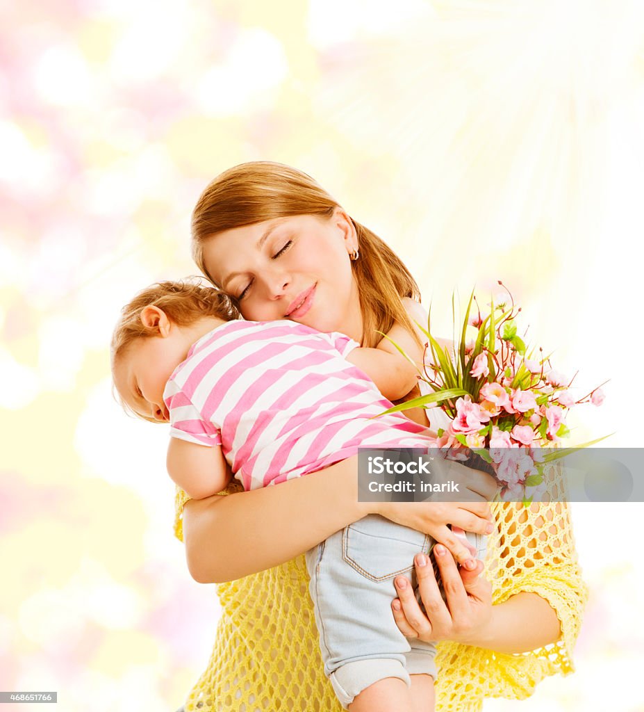 Baby Giving Gift Mother, Family Portrait Flowers, Kid Embracing Mom Baby Giving Gift to Mother, Family Portrait with Flowers, Little Kid Embracing Mom, Child Congratulate Mothers Date and Love Concept Mother's Day Stock Photo