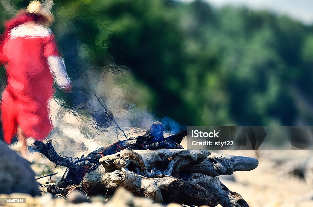 Campfire on the coast Woman in red dress near the campfire on the coast 2015 Stock Photo