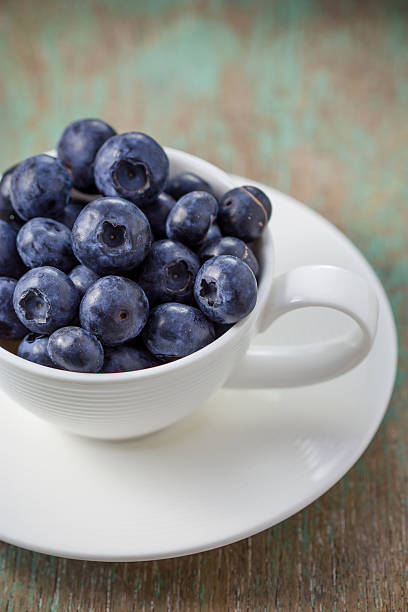 istock Blueberries in a cup on a wooden table. 468658958