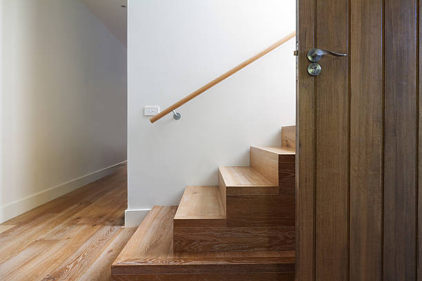 Modern staircase of oak wood beside front door horizontal Modern staircase of oak wood beside front door in contemporary home horizontal landing home interior stock pictures, royalty-free photos & images