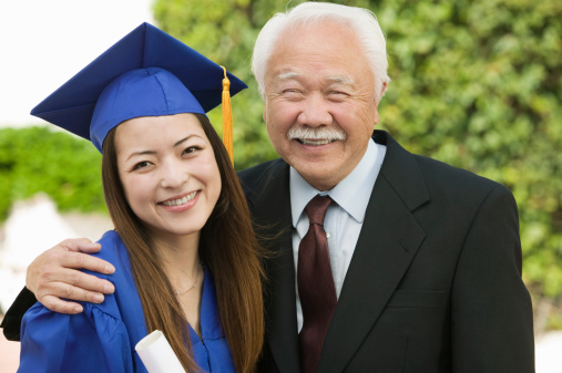 Portrait of young graduates embracing their parents on graduation