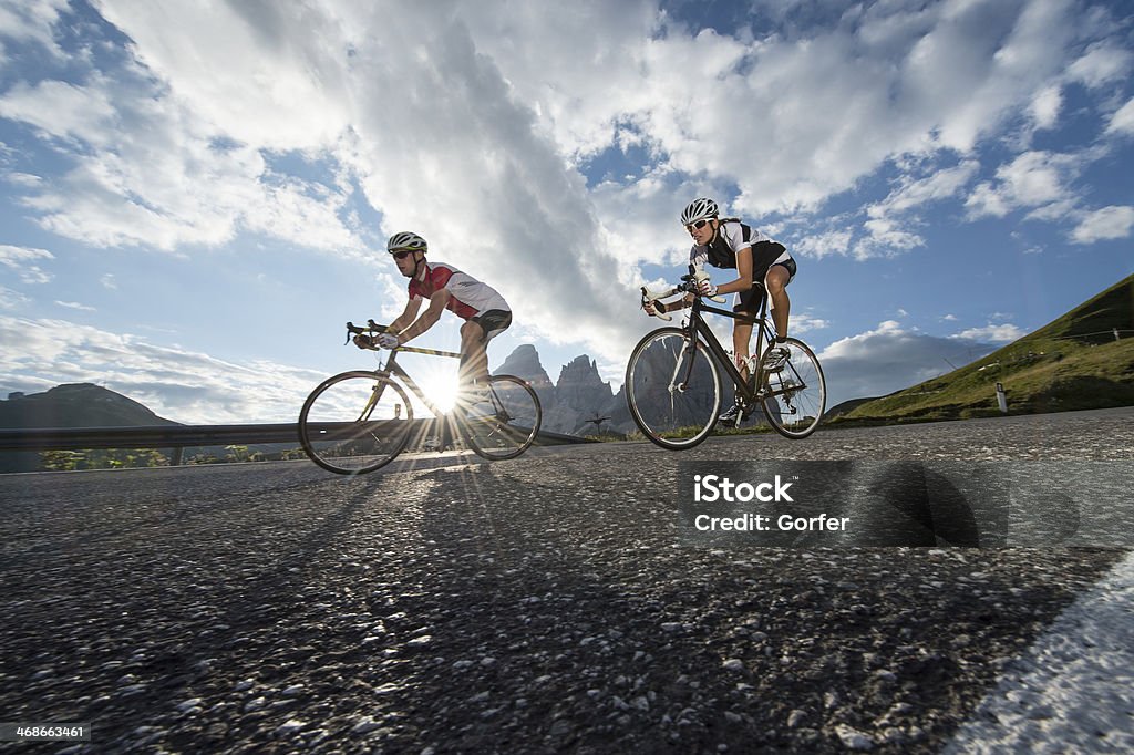 Road biking without words last rays of sunlight on the descent with the racing of Dolomites pass in italy Cycling Stock Photo