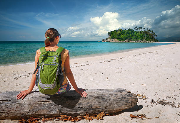 istock Young woman with backpack relaxing on coast and looking island 468668040
