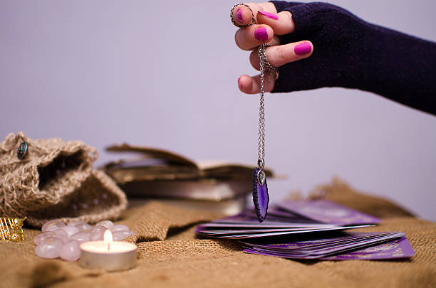 istock holds the pendulum over the tarot cards 468668566
