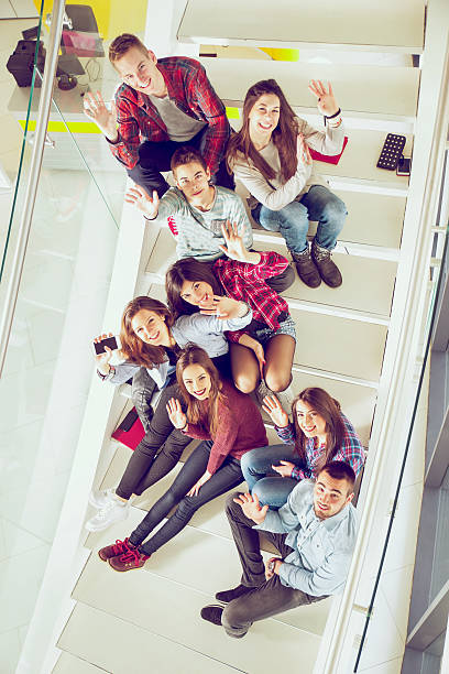 grupo mediano de los estudiantes de la escuela estudiando en pasos del hotel. - face to face teenage couple teenager couple fotografías e imágenes de stock