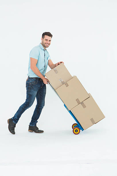 istock Happy delivery man pushing trolley of boxes 468671210