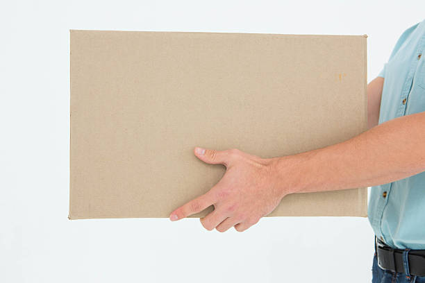istock Delivery man carrying cardboard box 468671352