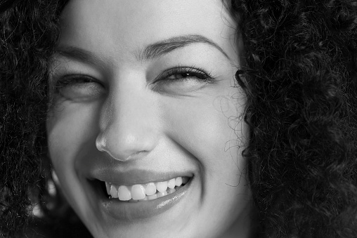 Closeup portrait of a happy girl smiling in black and white.